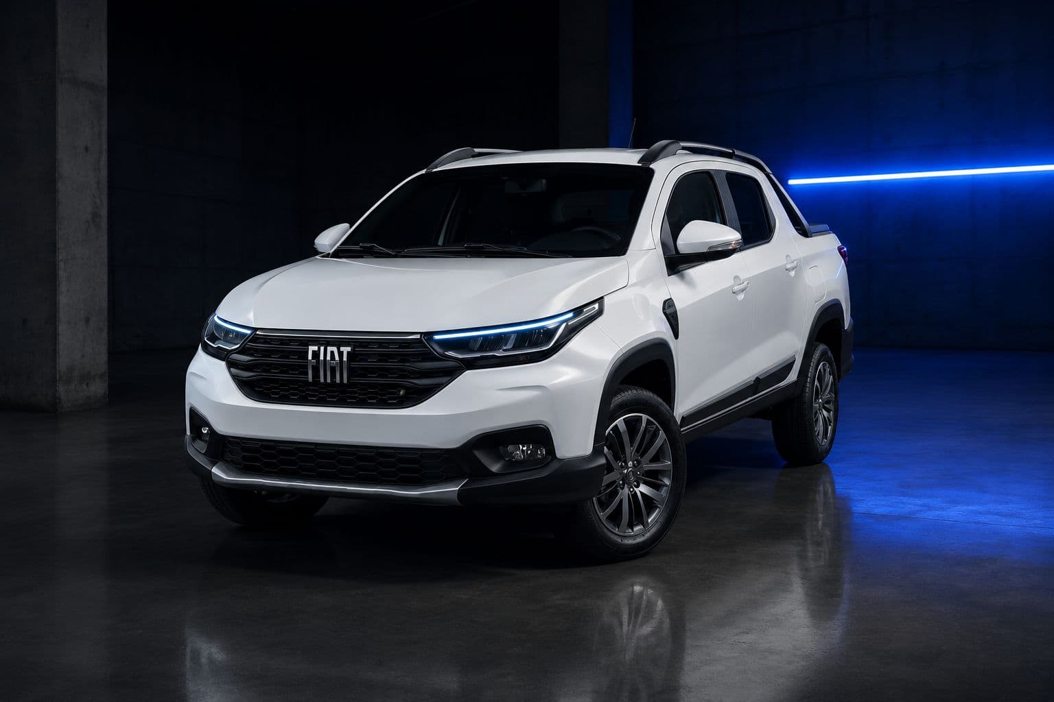Fiat Strada cabine dupla branca em galpão de concreto com faixa de luz azul ao fundo